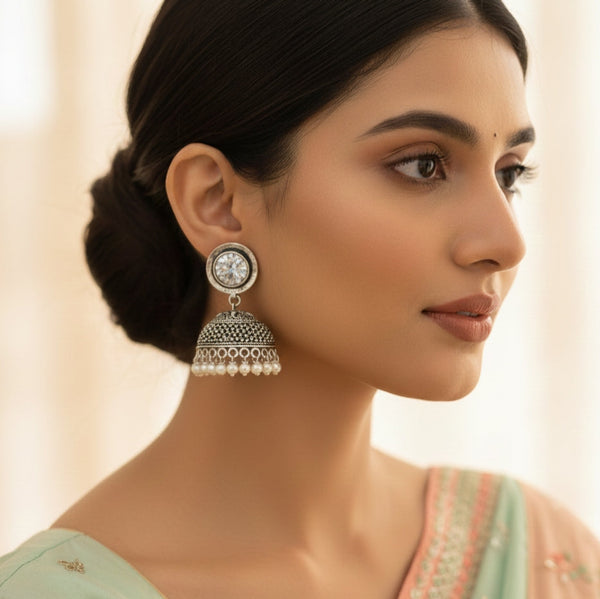 Woman wearing silver earrings with a soft background
