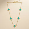 Close-up of turquoise clover detailing on gold stainless steel necklace by Evvara Vogue