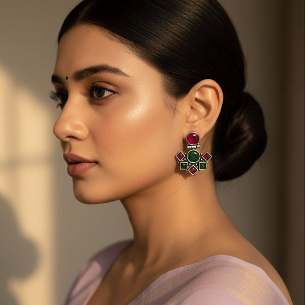 Woman wearing a pair of earrings with a neutral background