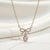 Gold bow necklace with blush pink teardrop stone
