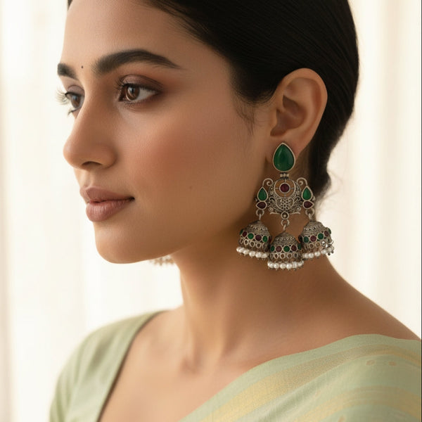 Woman wearing intricate earrings with a neutral background