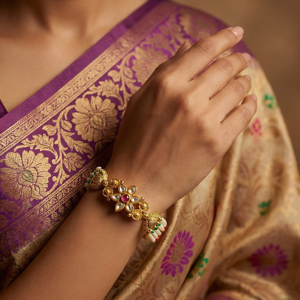 Lotus-inspired kundan floral motif with ruby center on pearl bracelet