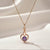 Rose gold heart pendant necklace with violet center stone on soft satin background