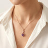 heart-shaped rose gold pendant with sparkling stones and purple gemstone