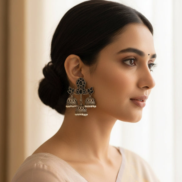 Woman wearing ornate earrings with a neutral background