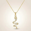 Minimal gold serpent pendant necklace reflecting light on luxury fabric background