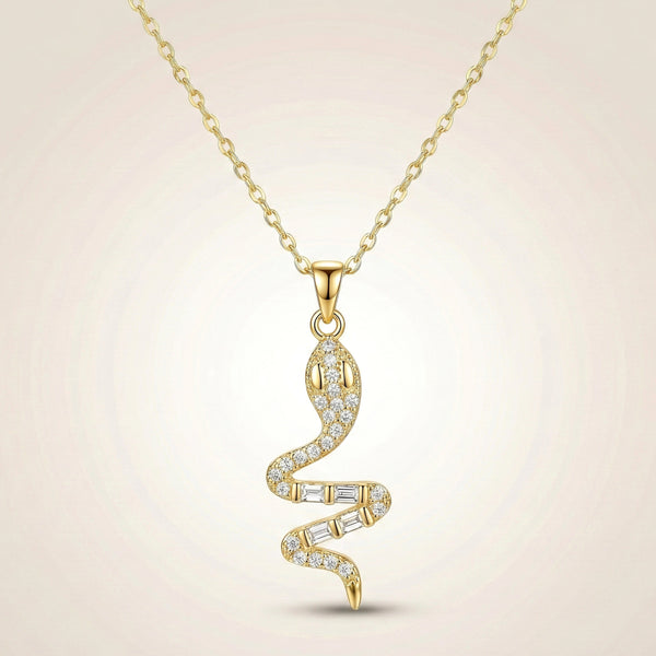 Minimal gold serpent pendant necklace reflecting light on luxury fabric background