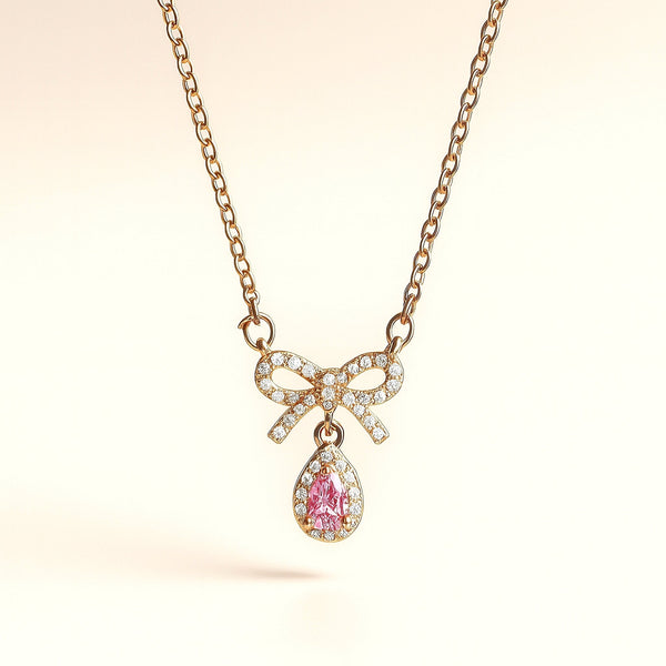 Minimal luxury pink teardrop necklace with gold bow detailing